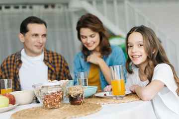 Selective focus of the girl having breakfast with parents