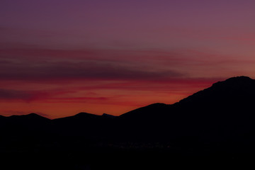sunset sky in dark mountain silhouette 