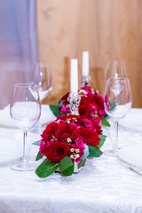 2 floral arrangements of red roses and carnations for table decoration (wedding, restaurant) on a server table, table setting