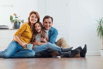 Happy smiling family sitting on floor together