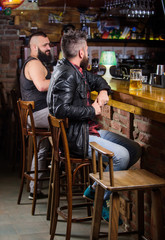 Fototapeta na wymiar Weekend lifestyle. Guy bearded man sit at bar counter in pub. Pub great place to dine drink and have fun. Hipster relaxing at pub. Man with beard spend leisure in dark pub. Brutal hipster relaxing