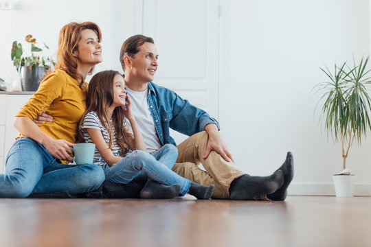 Happy family sitting on floor together at home