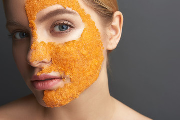 Calm woman showing peel off mask on half of her face