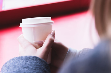 Beautiful girl hands hold paper cup with a drink