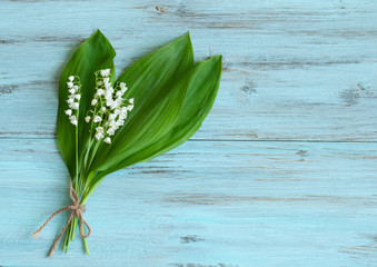 spring flowers, lilies of the valley on a wooden, turquoise background. Holiday card, concept