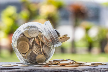 Coins in Bottle on nature background; money saving concept.  Investment concept. retirement concept.