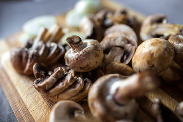 Champignon mushrooms on kitchen desk prepared to cook vegetarian healthy food. Vegan natural food concept