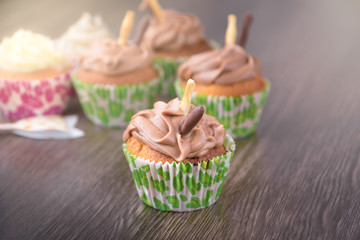 Chocolate cupcakes on wooden table background. Birthday celebration