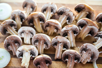 Champignon mushrooms on kitchen desk prepared to cook vegetarian healthy food. Vegan natural food concept
