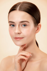 A beautiful female face. Perfect and clean skin of young caucasian woman on pastel studio background.