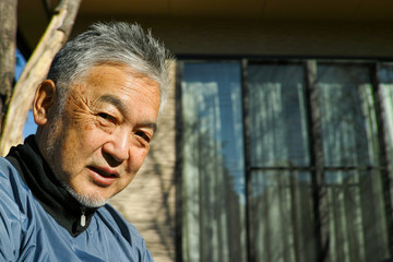 An older Asian man smiling
