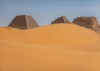 Fototapeta na wymiar Pyramids behind a large sand dune in the desert of Sudan