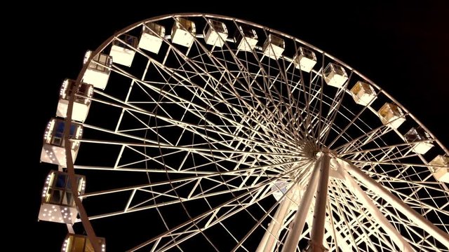 Ferris wheel. High luminous carousel on a dark background. Evening video. Black background