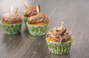 Delicious chocolate cupcakes on dark wooden table.