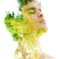 Double exposure of a young sexy man’s portrait blended with branches of a tropical palm tree,...