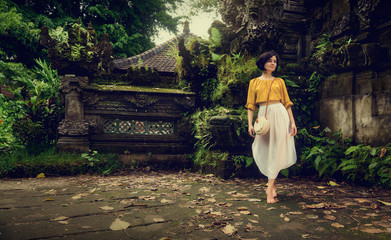 A girl in a white dress. Travel to Bali. Authentic architecture. Travel.	