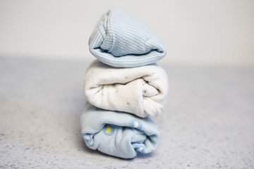 Colorful cotton folded clothes stack on white table empty space background,baby laundry.