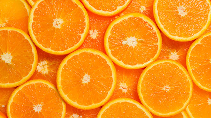 Slices of oranges as a background, top view.