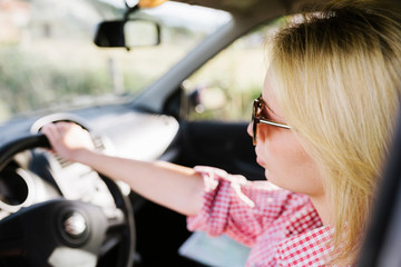 Fototapeta na wymiar Young blond woman with sunglasses driving car.