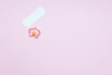 White ladies panty liner with red heart as symbol of menstrual blood on bright blue paper background. Top view, close up copy space, flat lay