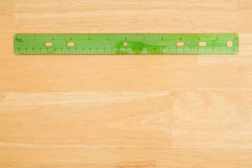 Plastic ruler on a wood desk background
