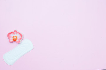 White ladies panty liner with red heart as symbol of menstrual blood on bright blue paper background. Top view, close up copy space, flat lay