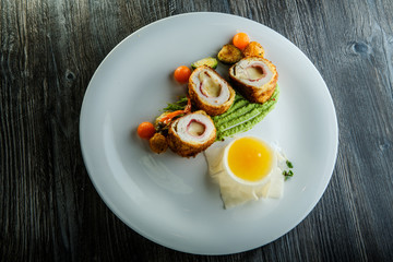 top view dissected chicken Kiev cutlets with grilled vegetables and yellow sauce