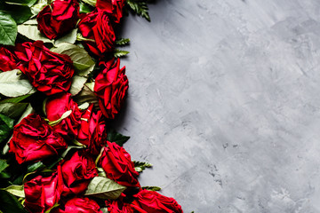 Red roses lying on gray concrete backgroung. Flat lay. Top view