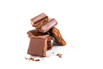 broken chocolate and hazelnuts on isolated white background.