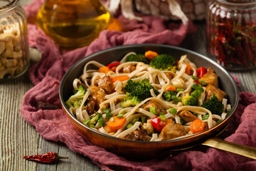 stir-fry pasta with chicken, broccoli and carrots.