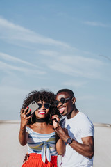 Black couple using the cell phone in the street