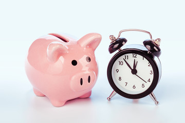 Piggy bank with alarm clock isolated on white background