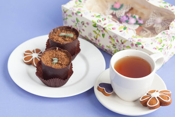 Homemade gingerbread, spring provence. Mother's Day. Sweet flowers, butterflies, a Sweet flowers, butterflies, a bicycle, and tea on the table. Lilac background.