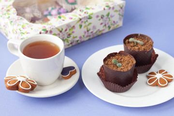 Homemade gingerbread, spring provence. Mother's Day. Sweet flowers, butterflies, a Sweet flowers, butterflies, a bicycle, and tea on the table. Lilac background.