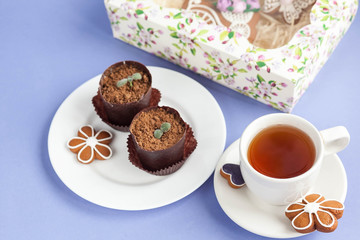 Homemade gingerbread, spring provence. Mother's Day. Sweet flowers, butterflies, a Sweet flowers, butterflies, a bicycle, and tea on the table. Lilac background.