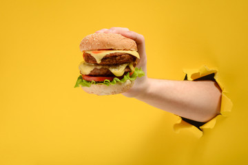 Hand holding a big burger
