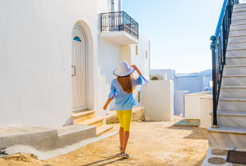 Little girl in white hat on a street in Greece, Mykonos
