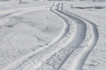 Winding snow scooter trail through winter landscape