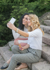 Two girls are taking selfies and eating ice cream