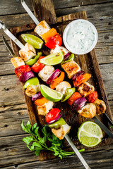 Grilled chicken skewers kebabs with vegetables, on rustic wooden table top view copy space