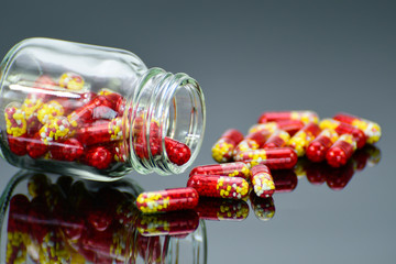 Pellets in transparent hard gelatin capsule on dark background.