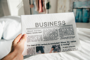 Naklejka premium cropped view of man holding business newspaper