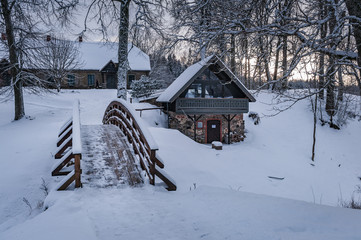 Naklejka premium View of the semicircular bridge and the snow covered tea house. Kubesele nature trail. Latvia.