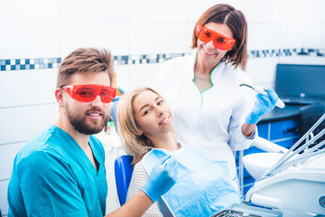 Smiling dentists with patient in stomathology clinic