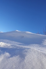 rural winter landscape with a field snow and the blue sky