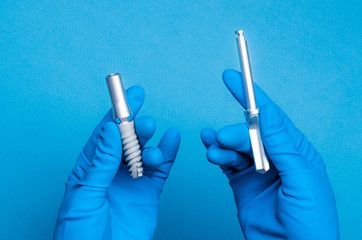 Hands in blue gloves holding dental implant tools on blue background