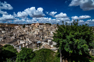 Summer day scenery street view of the amazing ancient town of the Sassi with white puffy clouds...