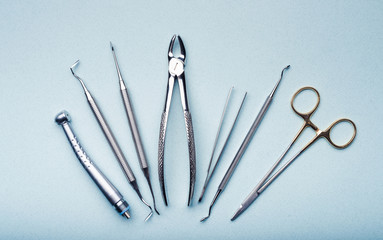 Dental metal tools composed on light blue background