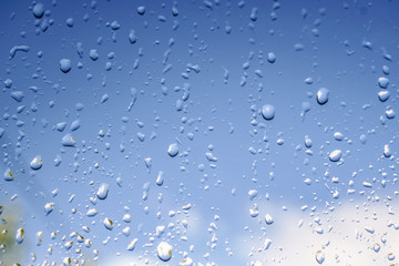 Beautiful raindrops on the window glass. Spring summer weather with warm rain. Stock photo
