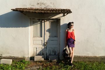 Girl in the summer in a black hat and sunglasses stands on the street